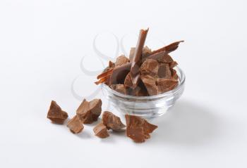 bowl of milk chocolate pieces on white background