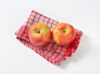 two ripe apples on checkered dishtowel