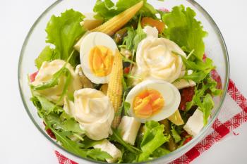 bowl of mixed salad with eggs and baby corn - close up