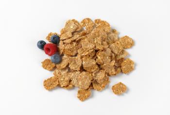 pile of breakfast cereal and berry fruits on white background