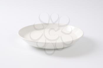 plate of fresh milk on off-white background with shadows