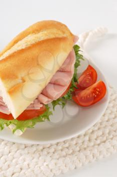 French bread sandwich with ham on white plate