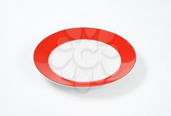 Empty dinner plate with wide red rim