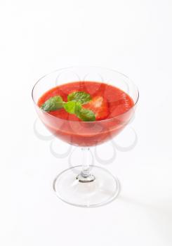 glass of cold strawberry puree on white background