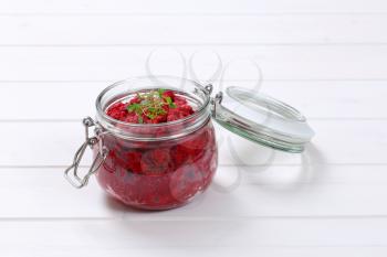 jar of fresh beetroot puree on white wooden background