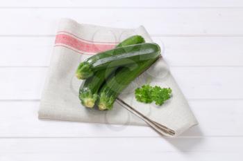 fresh green zucchini on folded dishtowel