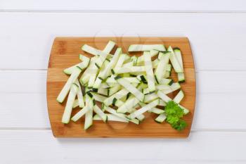 pile of zucchini strips on wooden cutting board