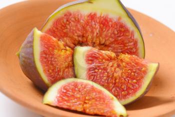 close up of fresh sliced fig on terracotta bowl