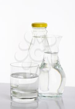 bottle, carafe and glass of fresh water on white background