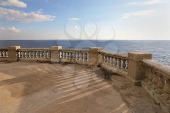 View from a terrace with old stone balustrade overlooking the sea