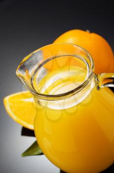 orange juice and fruit on black background