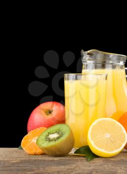 fresh tropical fruits and juice in glass isolated on black background