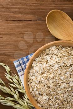 oat flakes in bowl on wooden background