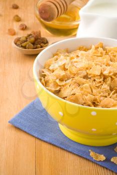 Bowl of corn flakes and milk on wood background