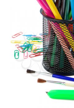 paintbrush, paper clips and pencil in holder isolated on white background