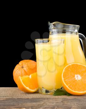 orange juice in glass and slices isolated on black background
