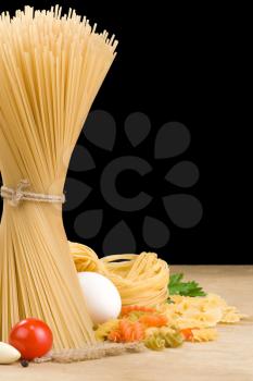 raw pasta and food vegetable isolated on black background