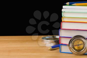 back to school supplies and books isolated on black background texture