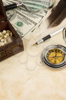 ink pen, magnifier, feather and compass near dollars