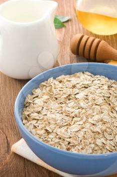 Bowl of oat and milk on wood background