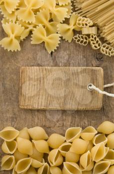 raw pasta and price tag label on wooden background