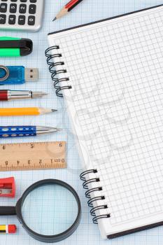 school accessories and checked notebook on graph grid paper