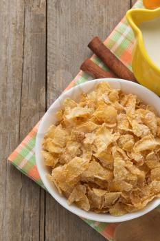 bowl of corn flakes on wooden background