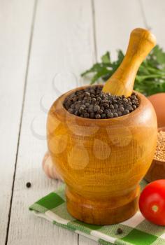 mortar with pestle and spices on wooden background