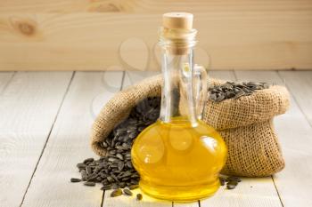 sunflower oil and seeds on wooden background
