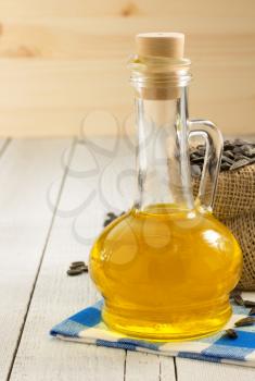 sunflower oil and seeds on wooden background