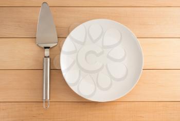 cake server and plate on wooden background