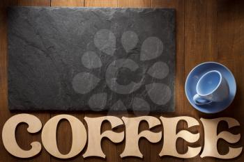 black slate stone and coffee letters on wooden background