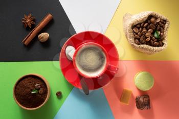 cup of coffee and ingredients at colorful background