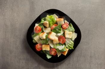 caesar salad in plate at table background
