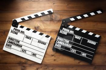 movie clapper board at wooden background texture, top view