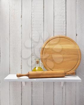 pizza cutting board and oil at shelf on  wooden background