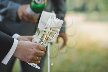 Process of filling by champagne of champagne in glasses outdoors.