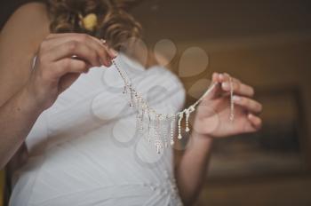 The bride dresses a necklace.