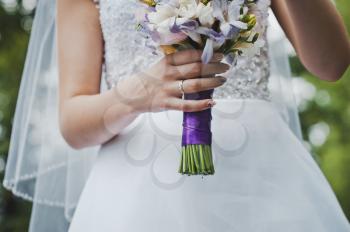 The bride holds a bunch of flowers.
