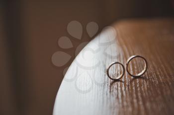 Wooden table with wedding rings.