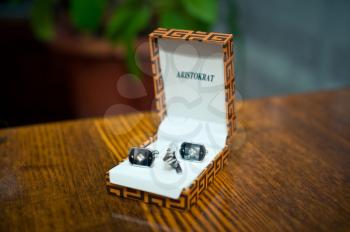 Man's cuff links in a box on a table.