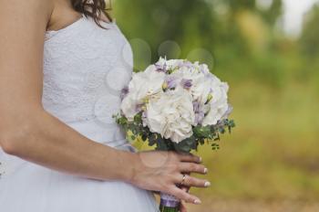 The bride is holding a white bouquet.
