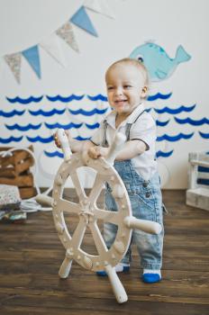 A little boy holds the wheel.