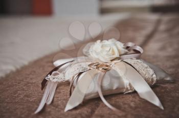 Decorative pillow with wedding rings.