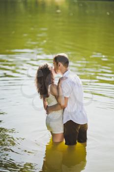 A tender embrace on the shore of the wooded lake.