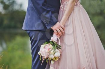 Bride and groom holding a bouquet of flowers.