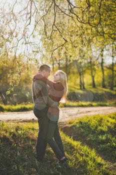 Lovers hug in the woods in the rays of the setting sun.