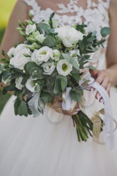 The bride is holding a wedding bouquet.