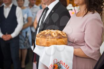 Mom holds a loaf in her hands waiting for the newlyweds.