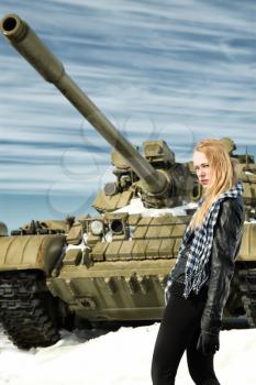 brutal girl stands amid battle tank